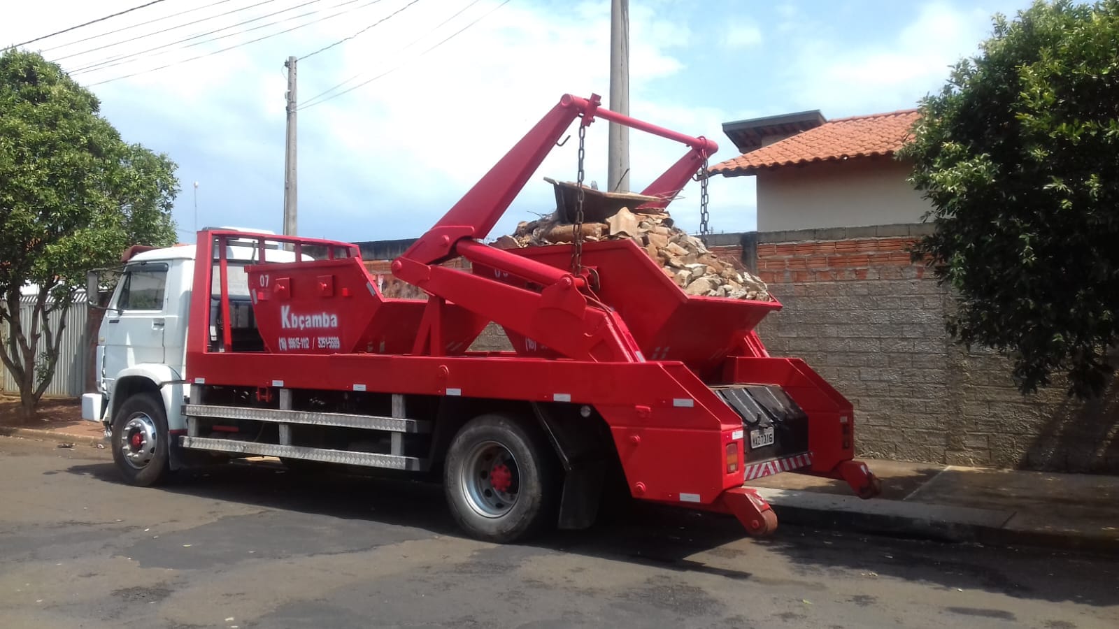 Caminhão da Kbçamba retirando uma caçamba cheia de entulho de obra em Guariba-SP